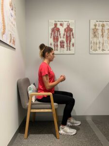 Woman seated and in position to perform exercises